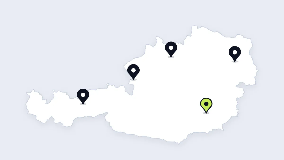 Österreich-Karte mit fünf Stecknadeln an den echten Orten von Wien, Linz, Salzburg, Innsbruck und Graz; Graz ist hellgrün hervorgehoben.