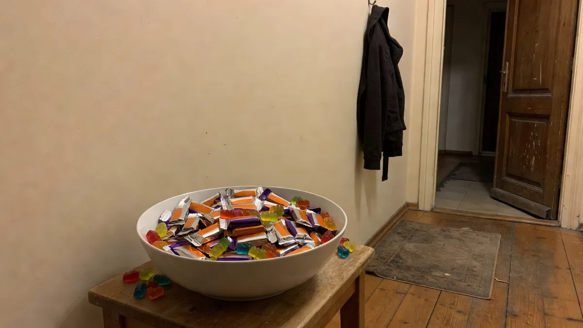 A bowl of wrapped chocolate bars and gummy bears by the front door, ready for children in costumes; no readable brand.